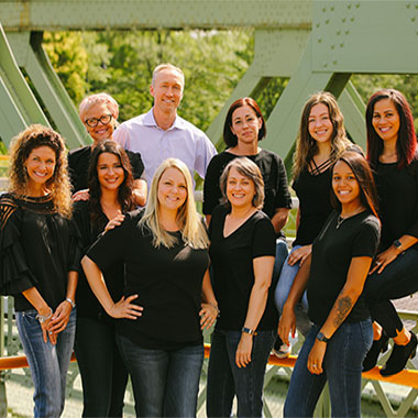Bateman Orthodontics team smiling together outdoors in front of modern building.