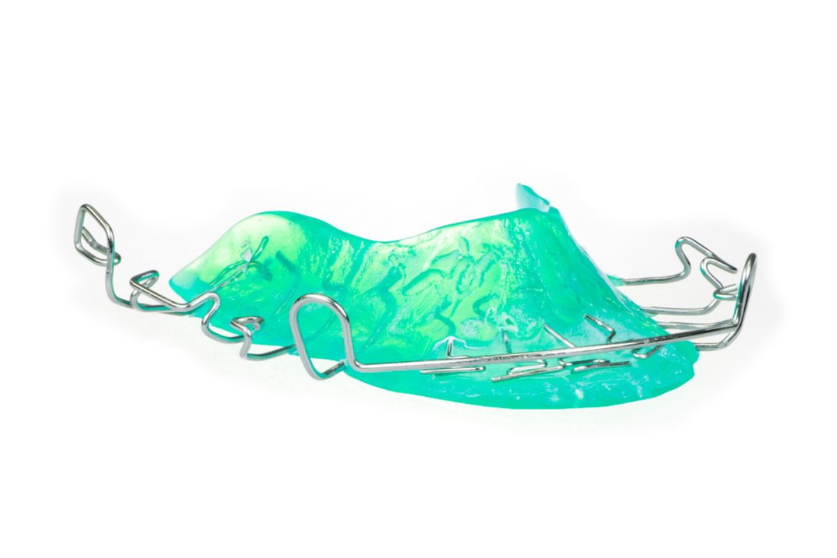 Turquoise orthodontic retainer with metal clasps and wires on white background.
